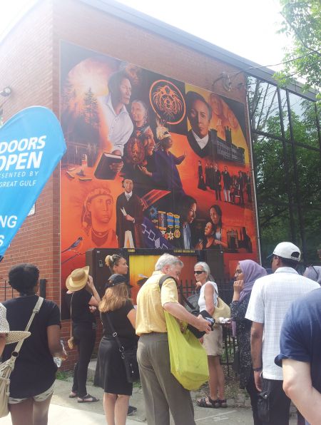 Mural of Dr O (Oon-hy-a-teh-ka) on the side of the Miziwe Biik Aboriginal Employment and Training building on Gerrard Street at Allan Gardens