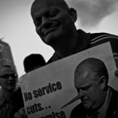 This activist holds a sign referring to Ford's promise not to cut services