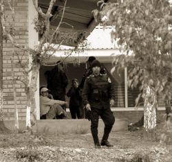 Nov. 28, 2009 - Inside the Red Comal school, police interrogate Julio, the day watchmen, who was beaten by the military when they arrived.