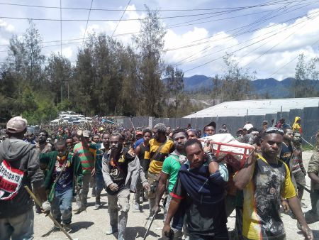 Porgerans carry a dead community member after they were shot by Barrick security, sparking riots. This occured the same week that Naylor was announced as a newcomer to Barrick's Board.