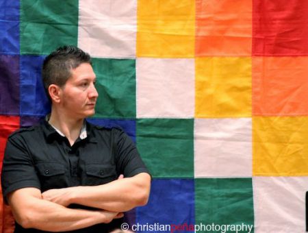 Raul Burbano, stands in front of the Wiphala, the indigenous Bolivian flag, at the People's Assembly he helped organize. (photo: Christian Peña)